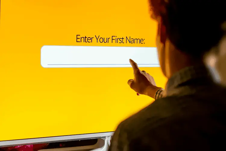 A contact form open on a laptop screen on a desk with a plant