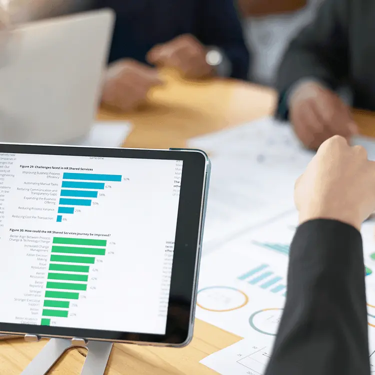 Tablet showing a performance chart on the table during an ad campaign discussion