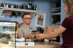 Customer and business owner talking at the counter of a small shop
