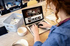 Photographer selecting photos on a laptop in a photo editing program