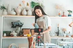 Small business owner filming social media content on a phone inside their own shop