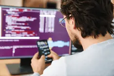 Web developer inspecting the browser network tab on a laptop screen
