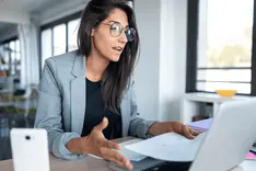 Small business owner reviewing a quote on a laptop in the office